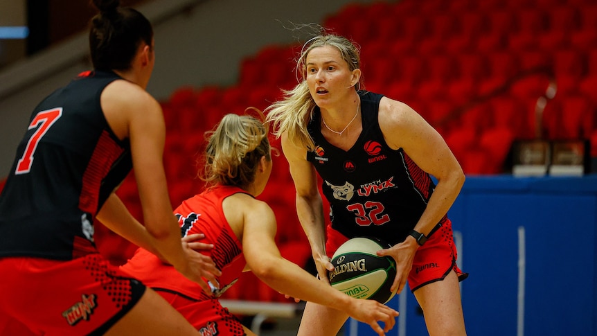 WNBL player Sami Whitcomb holds a basketball as she plays in a scrimmage at training.