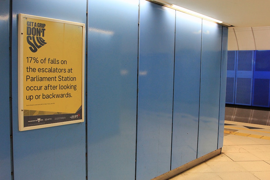A safety notice on the wall at Parliament Station warns 17% of escalator falls occur after looking up or backwards.