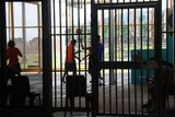 A group of kids play basketball in a youth detention facility in the NT.
