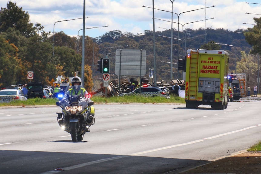 A truck can be seen lying on its roof at the scene of a fatal accident on the Barton Highway in Canberra.