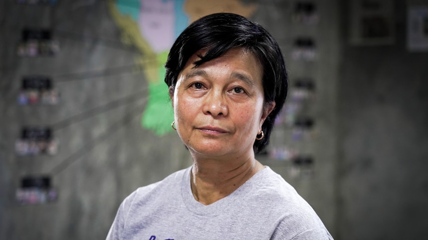 A Thai woman with close cropped hair in a grey t-shirt