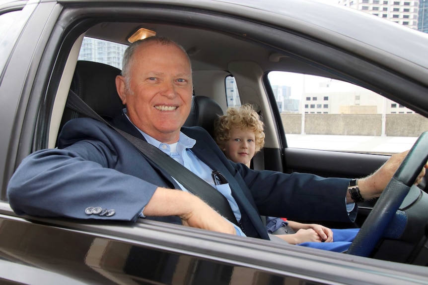 Ian Britza sits in his black ute with his 10-yeaer-old son Samuel.