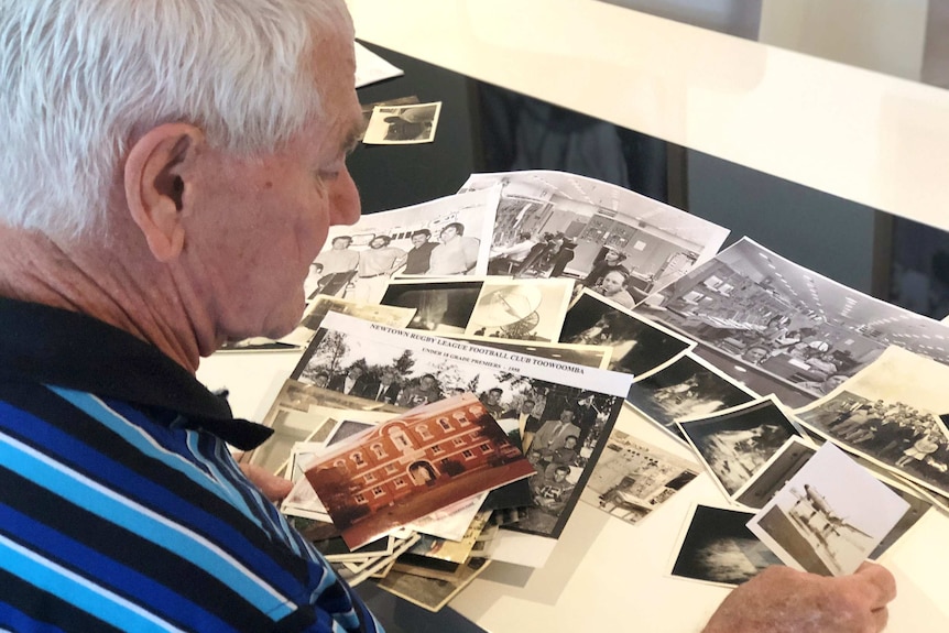 Kevin Gallegos looks at a number of black and white photos.