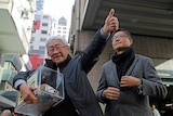 Retired archbishop of Hong Kong Cardinal Joseph Zen holds a donation box.