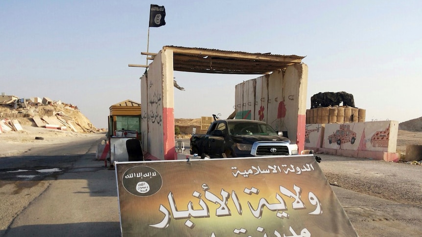 A sign in Arabic reads "Islamic State, the Emirate of Anbar, City of Rawah" at Rawah's main entrance.