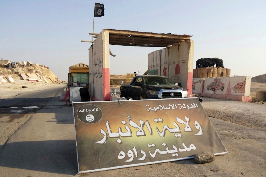 A sign in Arabic reads "Islamic State, the Emirate of Anbar, City of Rawah" at Rawah's main entrance.