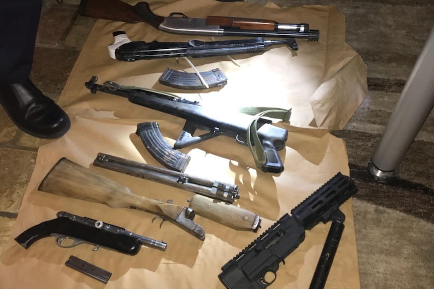 A number of guns seized by ACT Police during a raid on a home in Monash, ACT laid out on the floor.