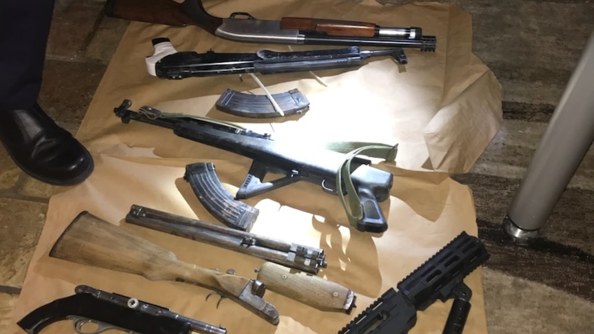 A number of guns seized by ACT Police during a raid on a home in Monash, ACT laid out on the floor.