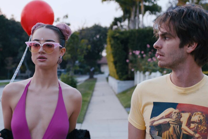 Grace Van Patten and Andrew Garfield in the film Under the Silver Lake, dressed in bright outfits on a californian street