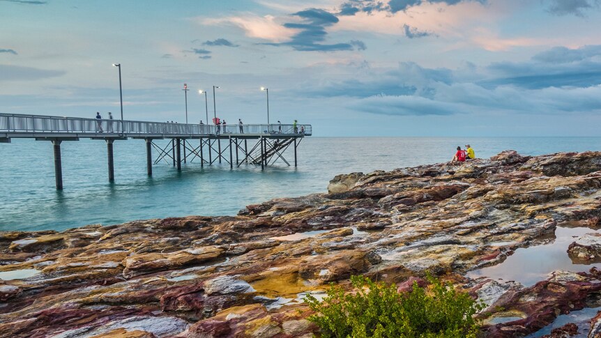 A rocky outcrop and a pier off Darwin's coastline