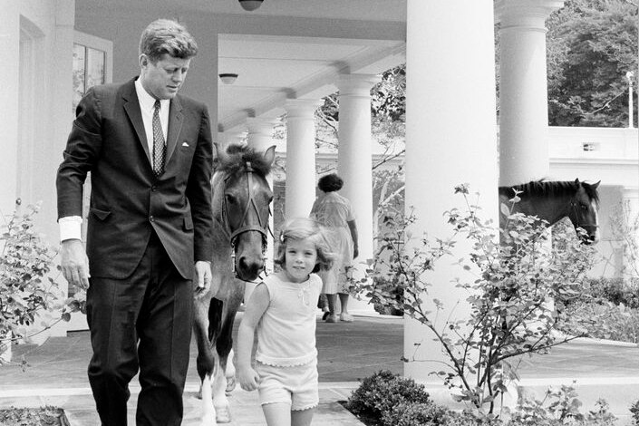 JFK and Caroline Kennedy walking down the White House portico together 