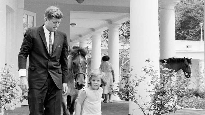 JFK and Caroline Kennedy walking down the White House portico together 