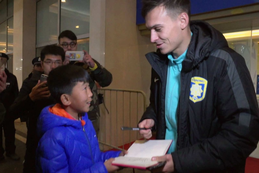 Young Chinese football player Gao Baosen, 12, meets Socceroo Trent Sainsbury, who plays for Jiangsu Suning FC.