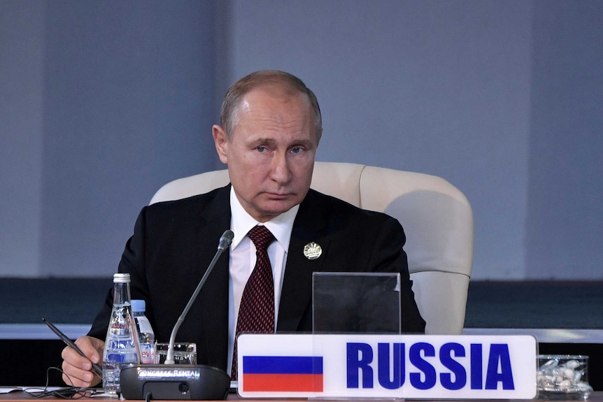 Vladimir Putin is seen seated in a session of the BRICS summit in Johannesburg.