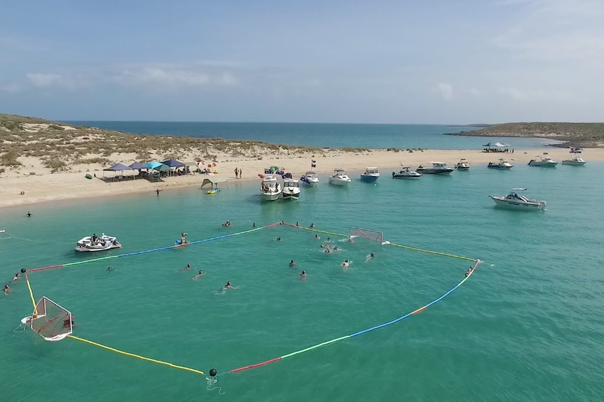 Boats line up on Malus Island in front of a water polo field