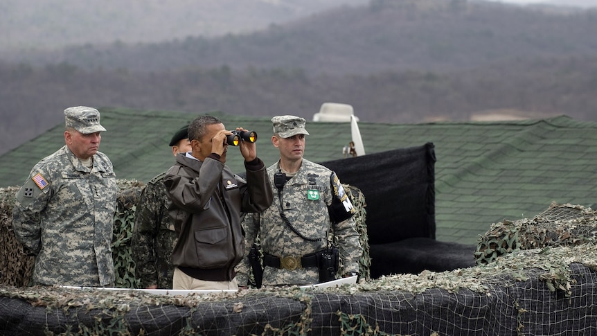 US president Barack Obama looks through binoculars towards North Korea from Observation Post Ouellette. (AFP: Saul Loeb)