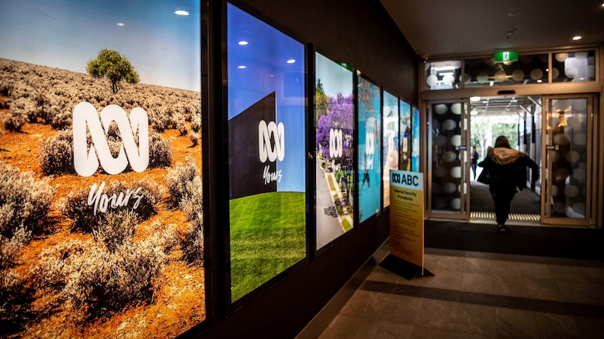 Colourful digital posters with the branding "ABC yours" in the foyer of a building.