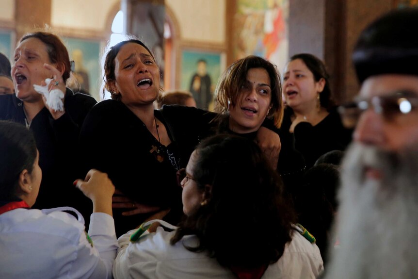 Relatives react as they mourn for the victims of the Palm Sunday bombings.