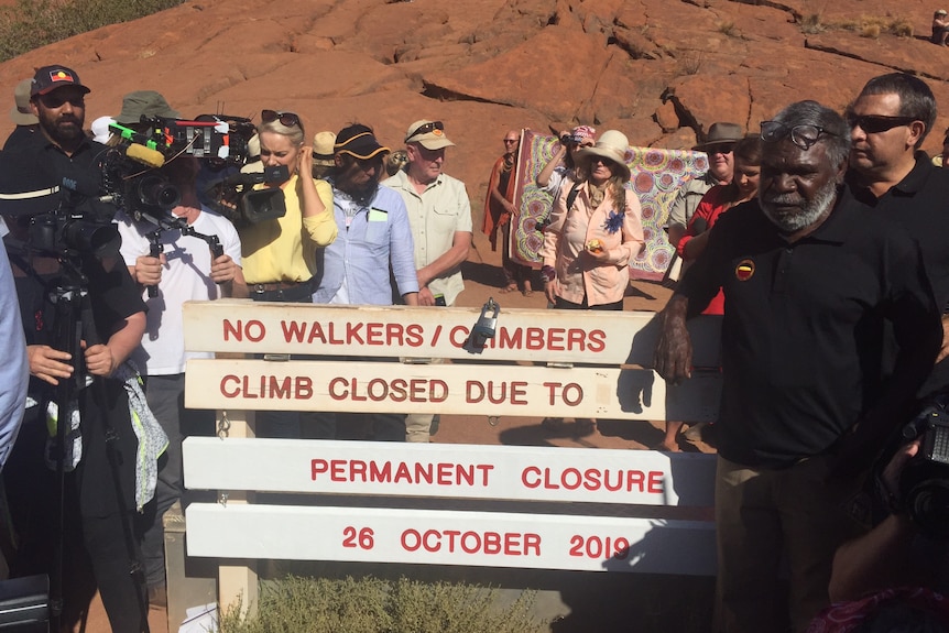Media and traditional owners gathered around the new closed sign at Uluru
