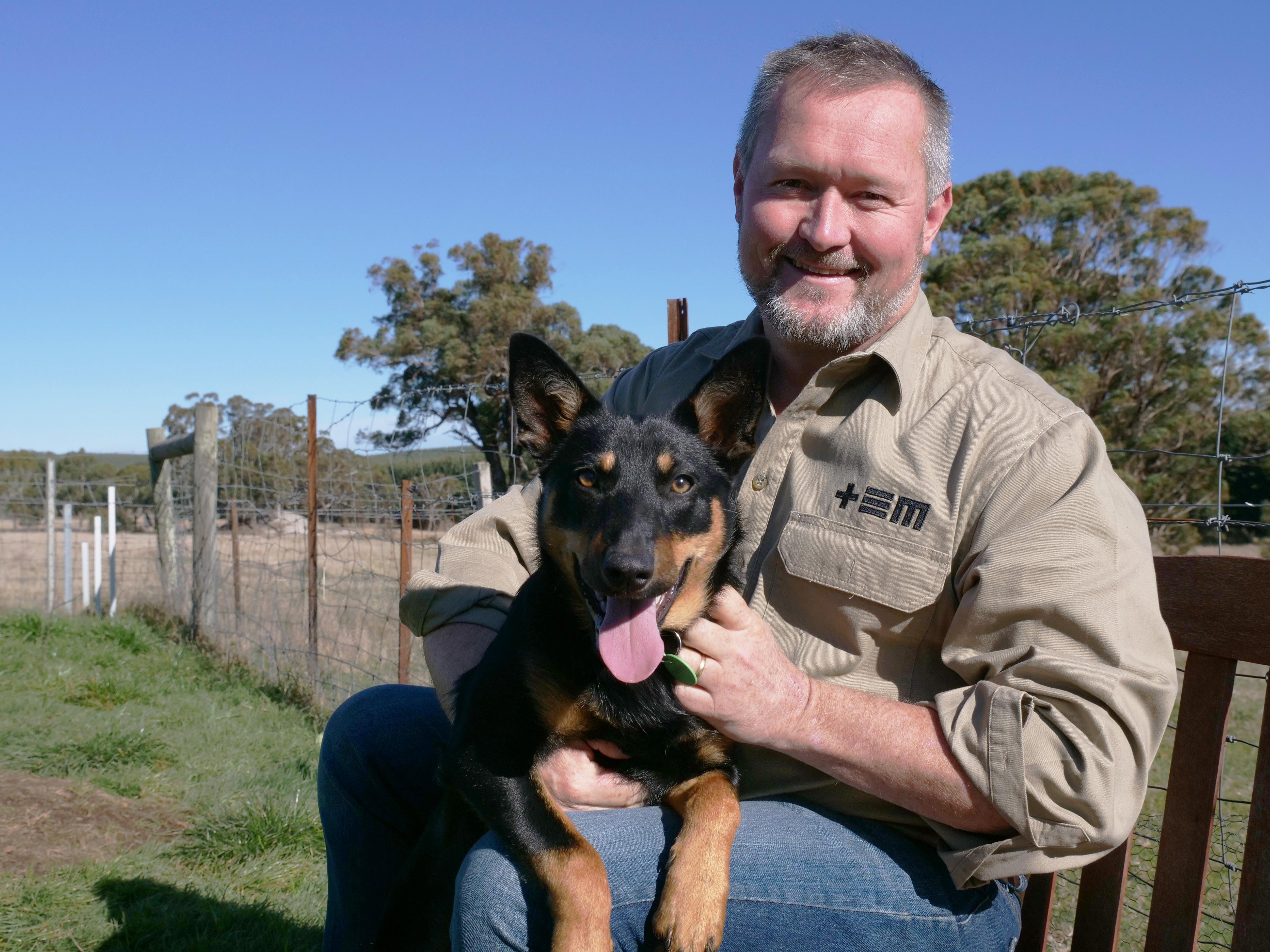 A man sitting outside with a dog