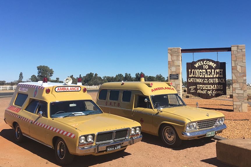 A pair of heritage ambulance vehicles stops outside Longreach, western Queensland