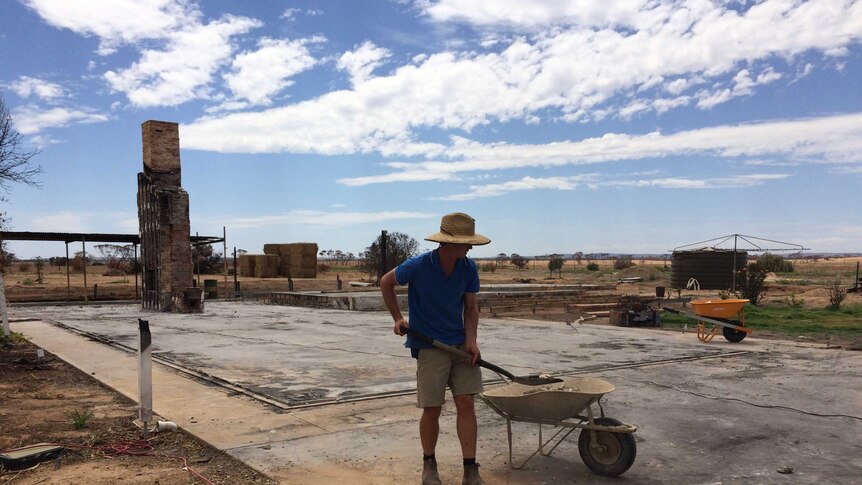 Ed Cay cleaning up the last bits of rubble around his home