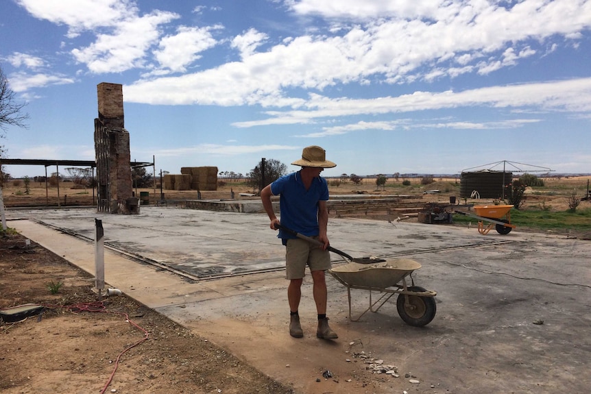 Ed Cay cleaning up the last bits of rubble around his home