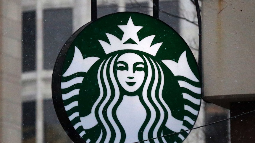 The Starbucks logo is seen on a shop's window.