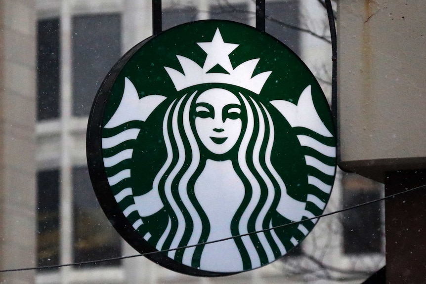 The Starbucks logo is seen on a shop's window.