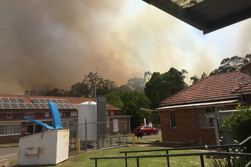 Smoke can be seen above two buildings.