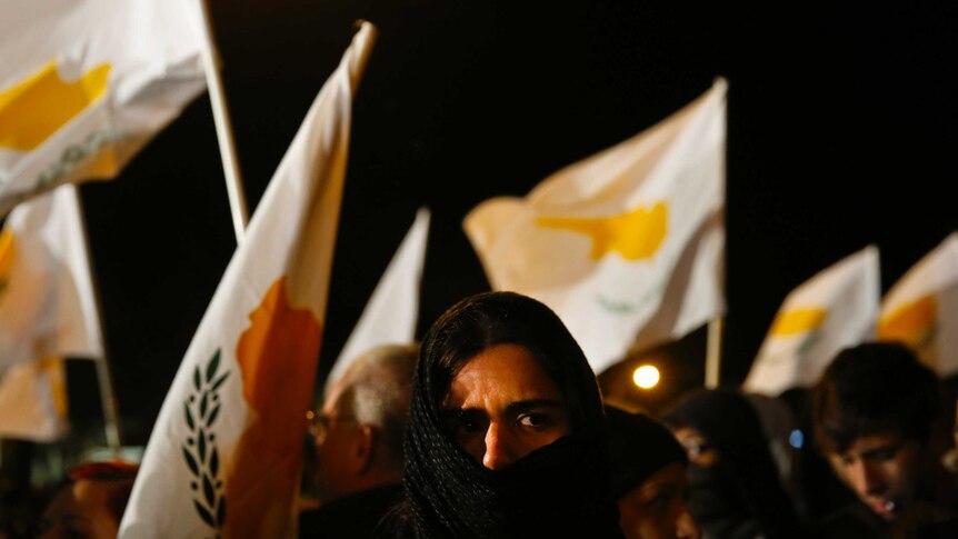 Cypriot protesters fly flags outside parliament