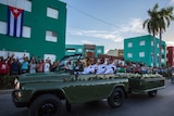 The motorcade carrying Fidel Castro's ashes drives along a street lined with people.