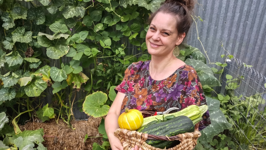 Koren Helbig with produce grown in her straw bale garden beds.