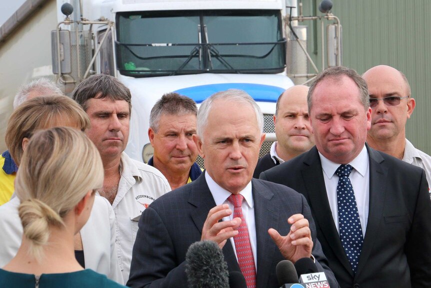 Malcolm Turnbull, standing in front of a truck, gestures as he speaks to truck drivers.
