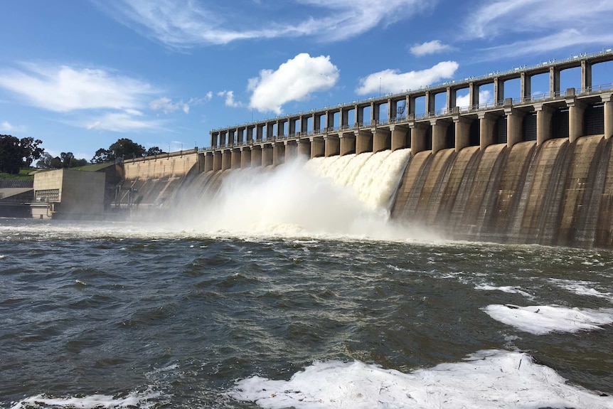 Hume Dam's spillway with foaming water spilling into the river below