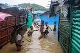 Rohingya refugee children play in flood waters at the Rohingya refugee camp