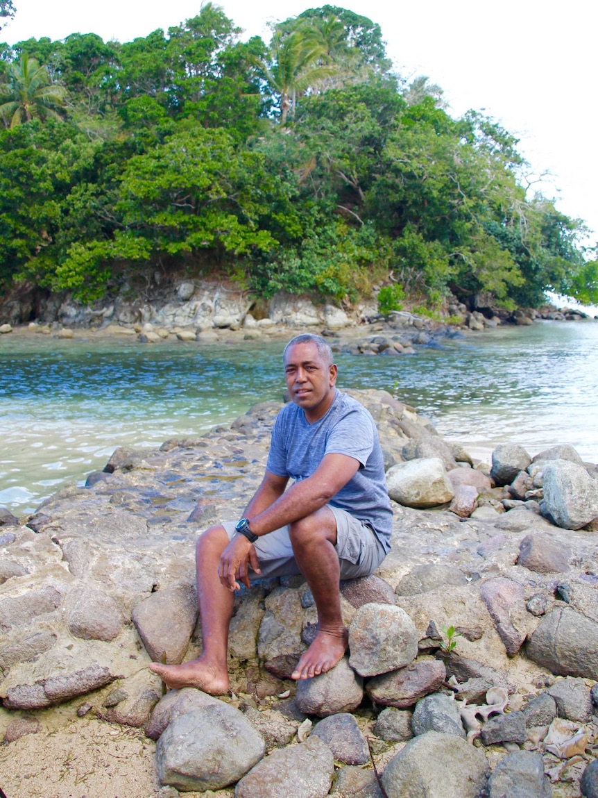 A Fijian man smiles in a black shirt with a white pattern.