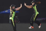 Australia's Megan Schutt (R) and Meg Lanning celebrate win over England at World T20 in New Delhi.
