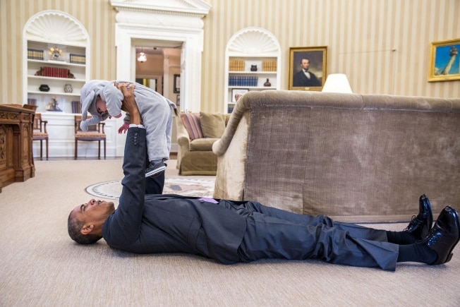 President Barack Obama holds up a young child in an elephant costume.