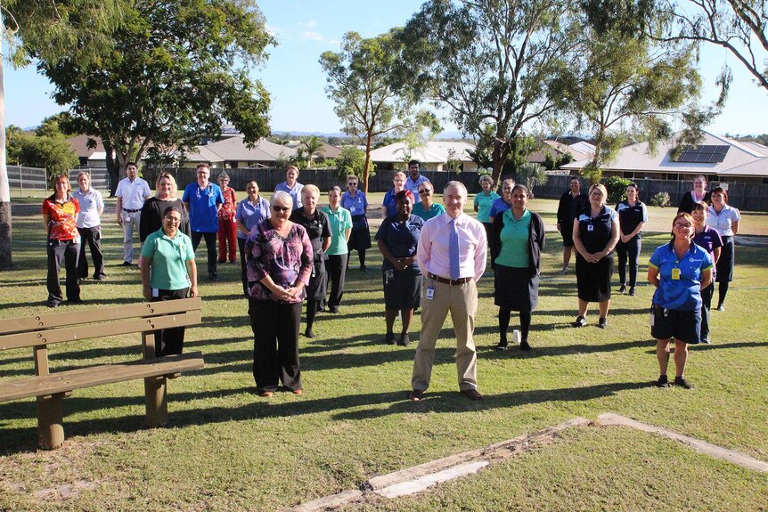 Some nurses and medical staff in Rockhampton socially distance for a group photo in a park.