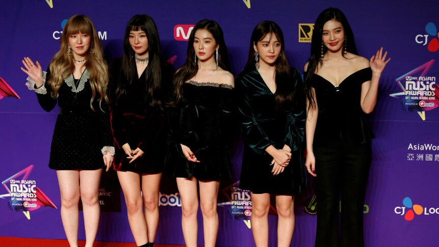 Red Velvet pose in front a billboard