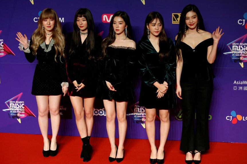 Red Velvet pose in front a billboard