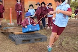 Students pull eachother along an obstacle course in an old plastic crate at West Greenwood Primary School.