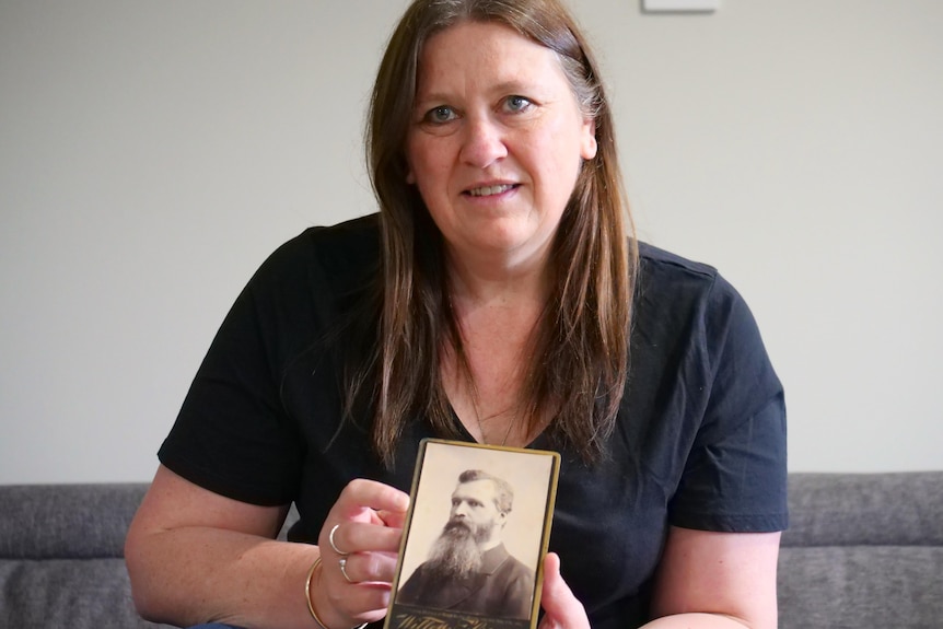 A woman holding an old photo 