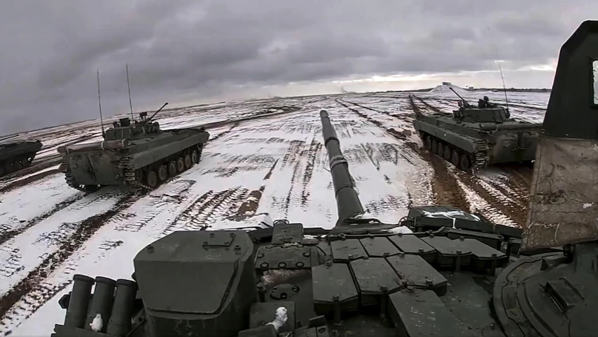 Three tanks on a road with snow.