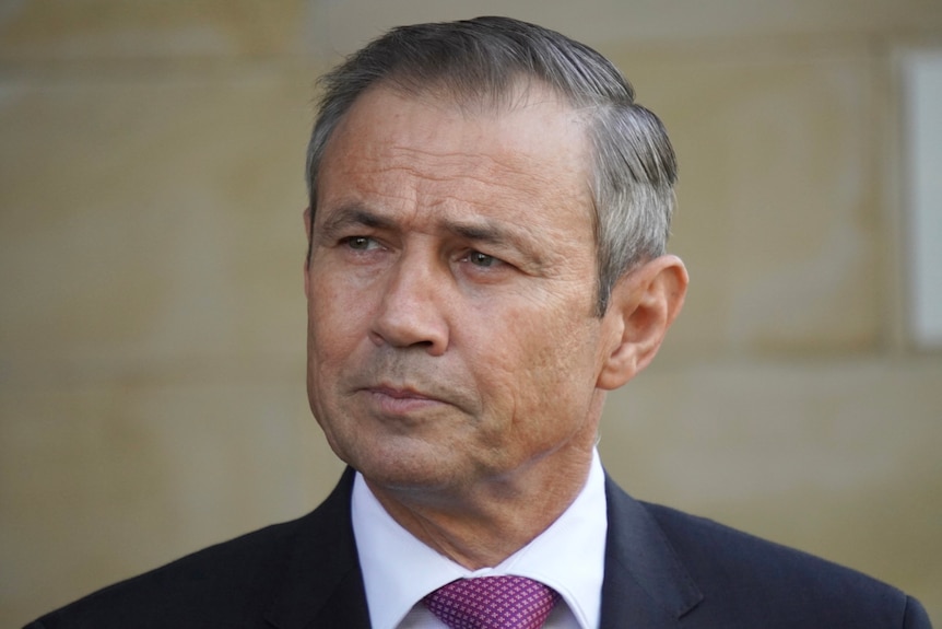 A tight head and shoulders shot of a frowning WA Health Minister Roger Cook.