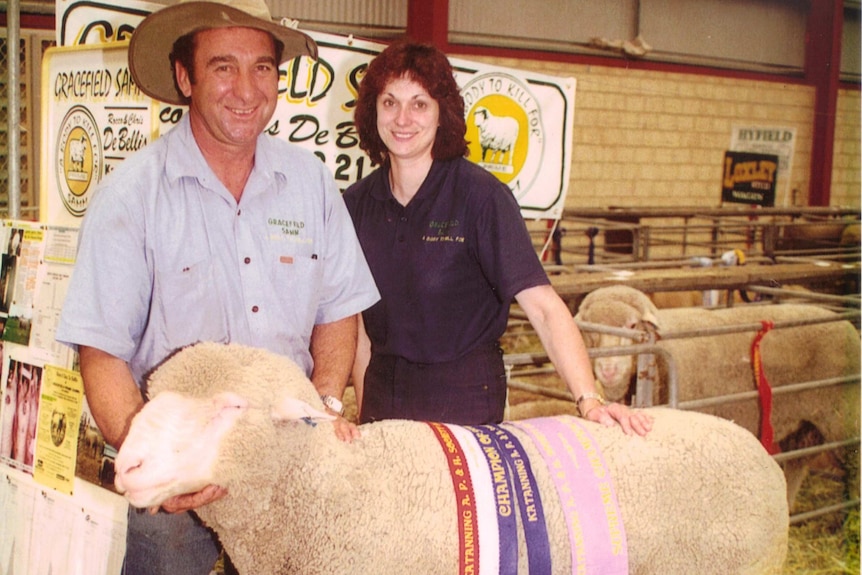 A man and a woman stand in front of an award winning South African Meat Merino