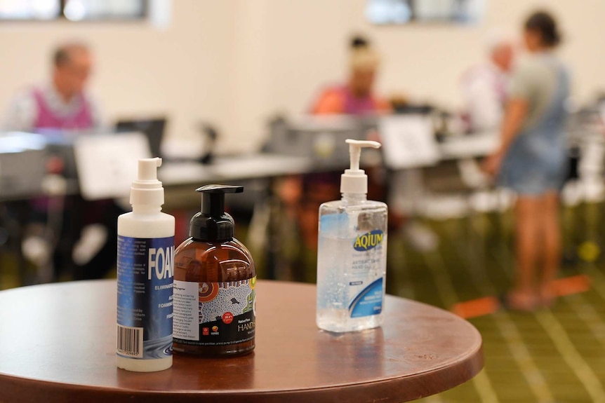 Three bottles of hand sanitiser on a table.