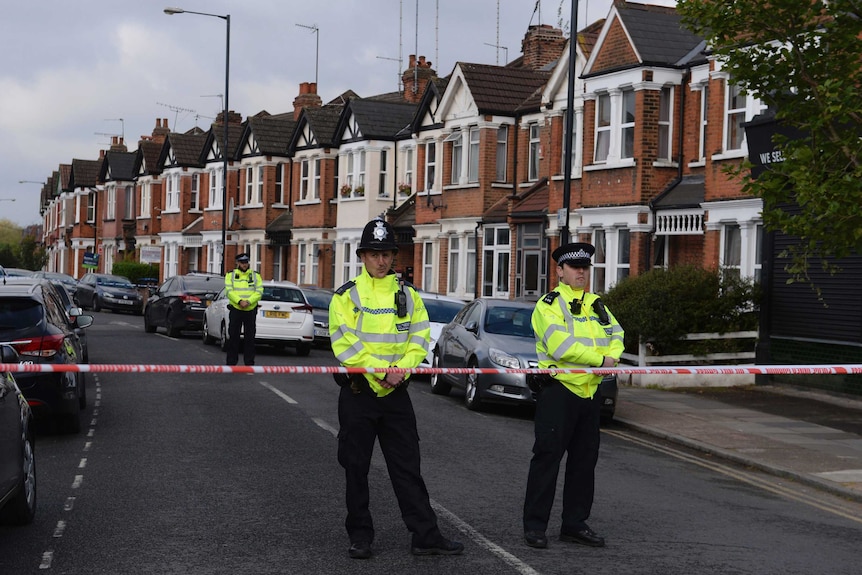 Police officers stand guard at a cordoned off area in Harlesden Road, north London.