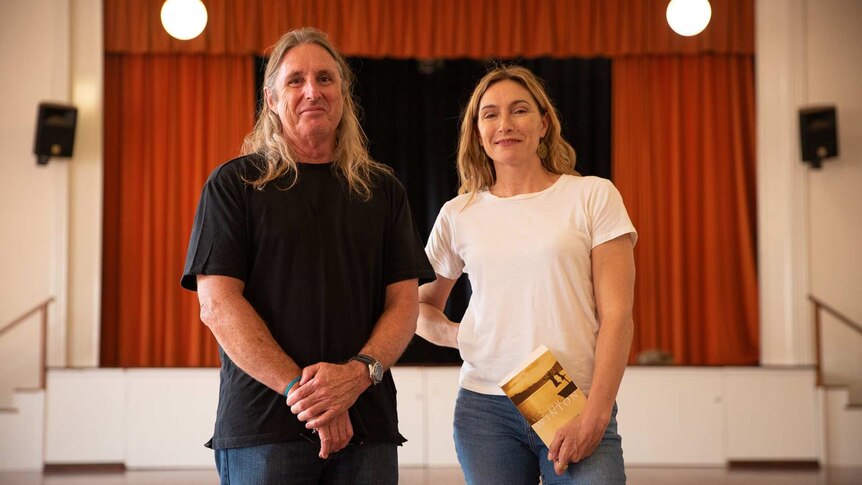 Author Tim Winton and actor Claudie Karvan stand in front of a theatre stage